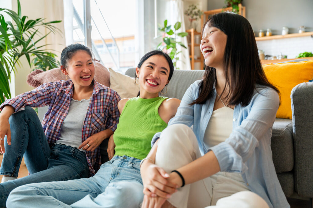 Three young women talking and laughing at home